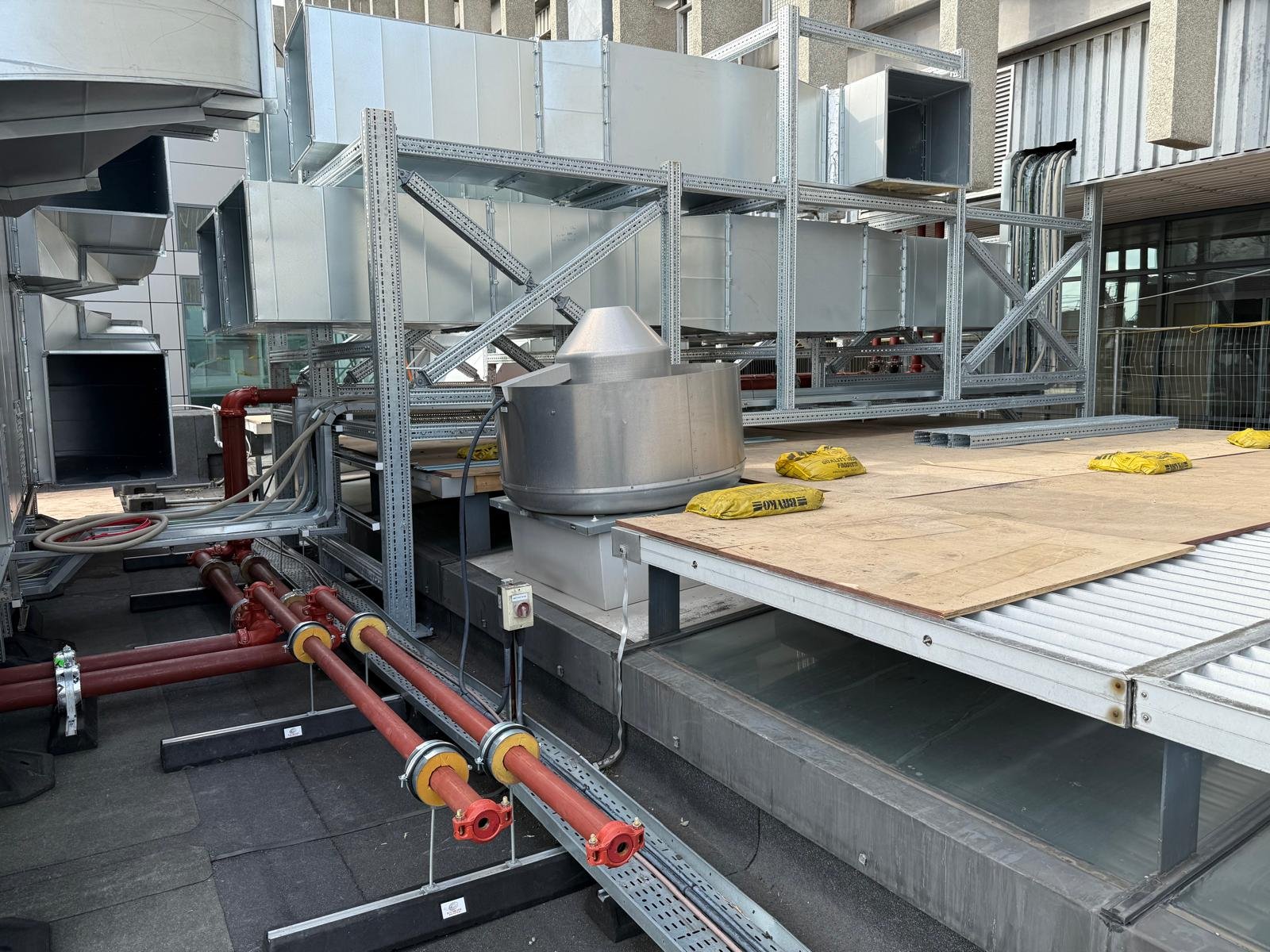 Rooftop mechanical plant and red heating pipework installed by M&F Mechanical